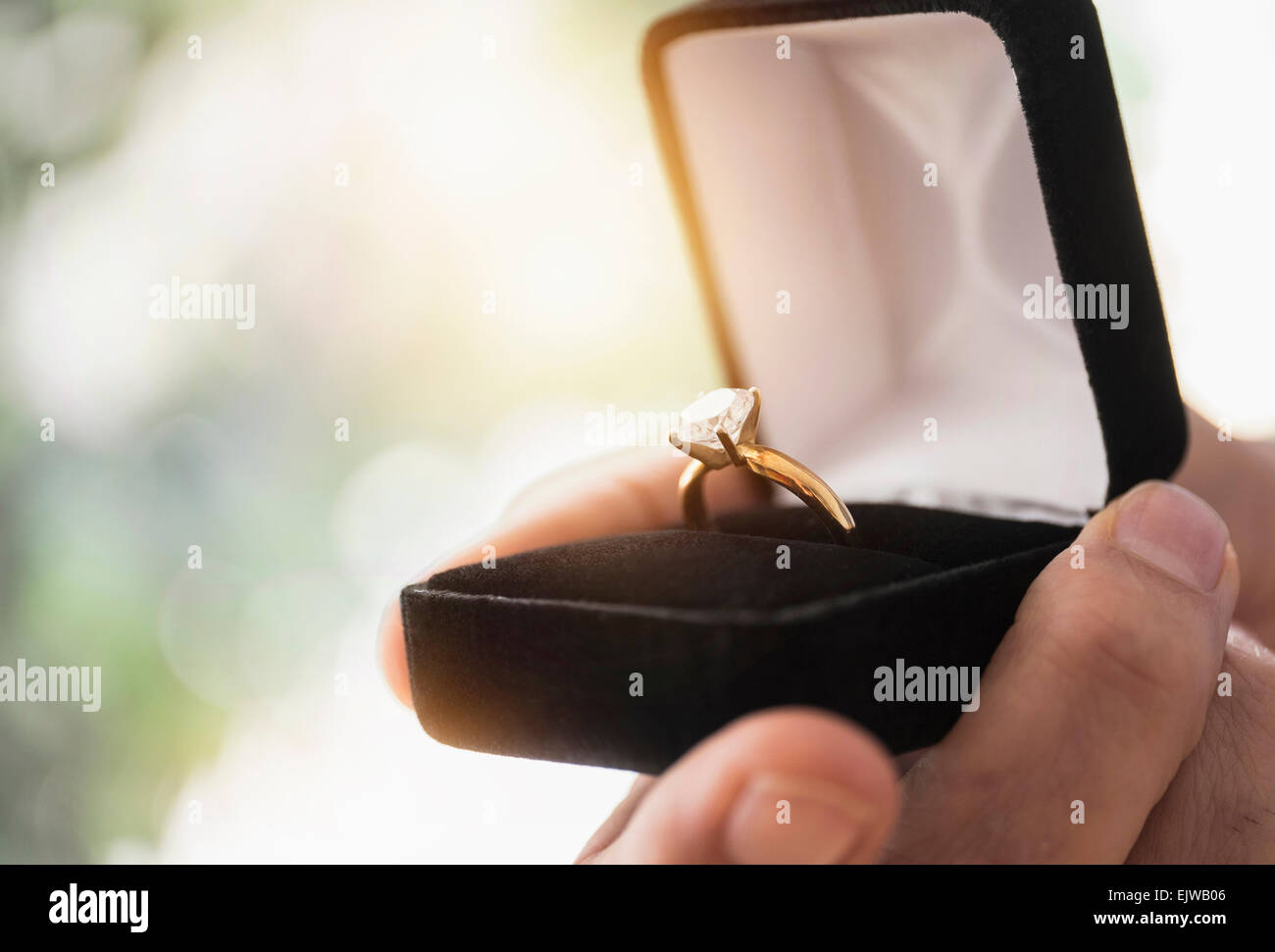 Nahaufnahme eines Mannes Hand mit offener Kasten mit Verlobungsring Stockfoto