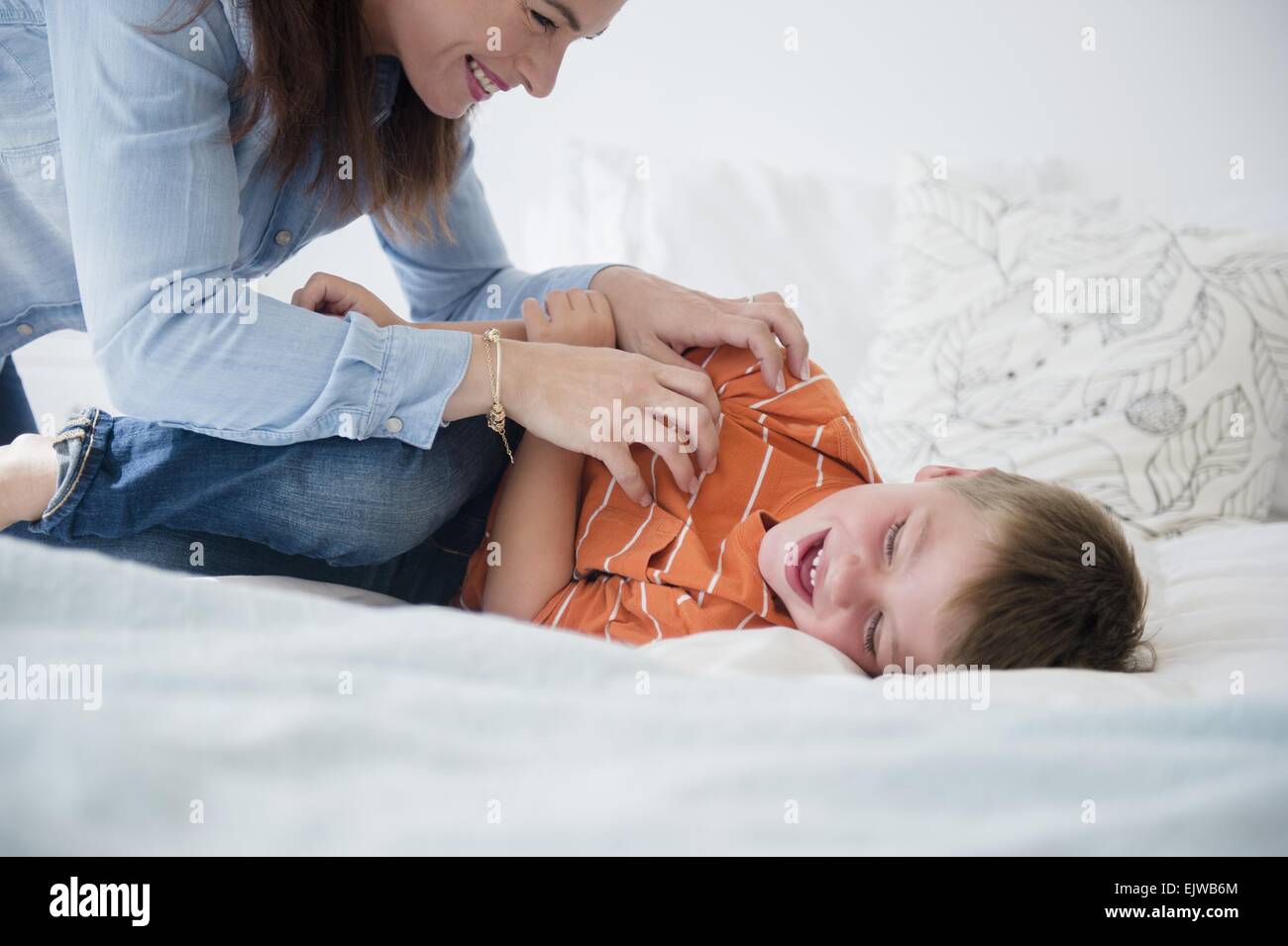 Mutter und Sohn (6-7) spielt im Bett Stockfoto
