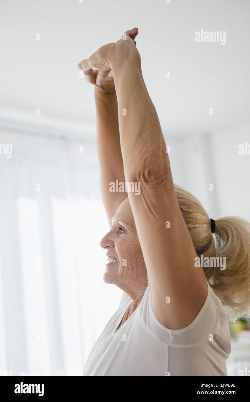 Ältere Frau mit erhobenen Armen Stockfoto