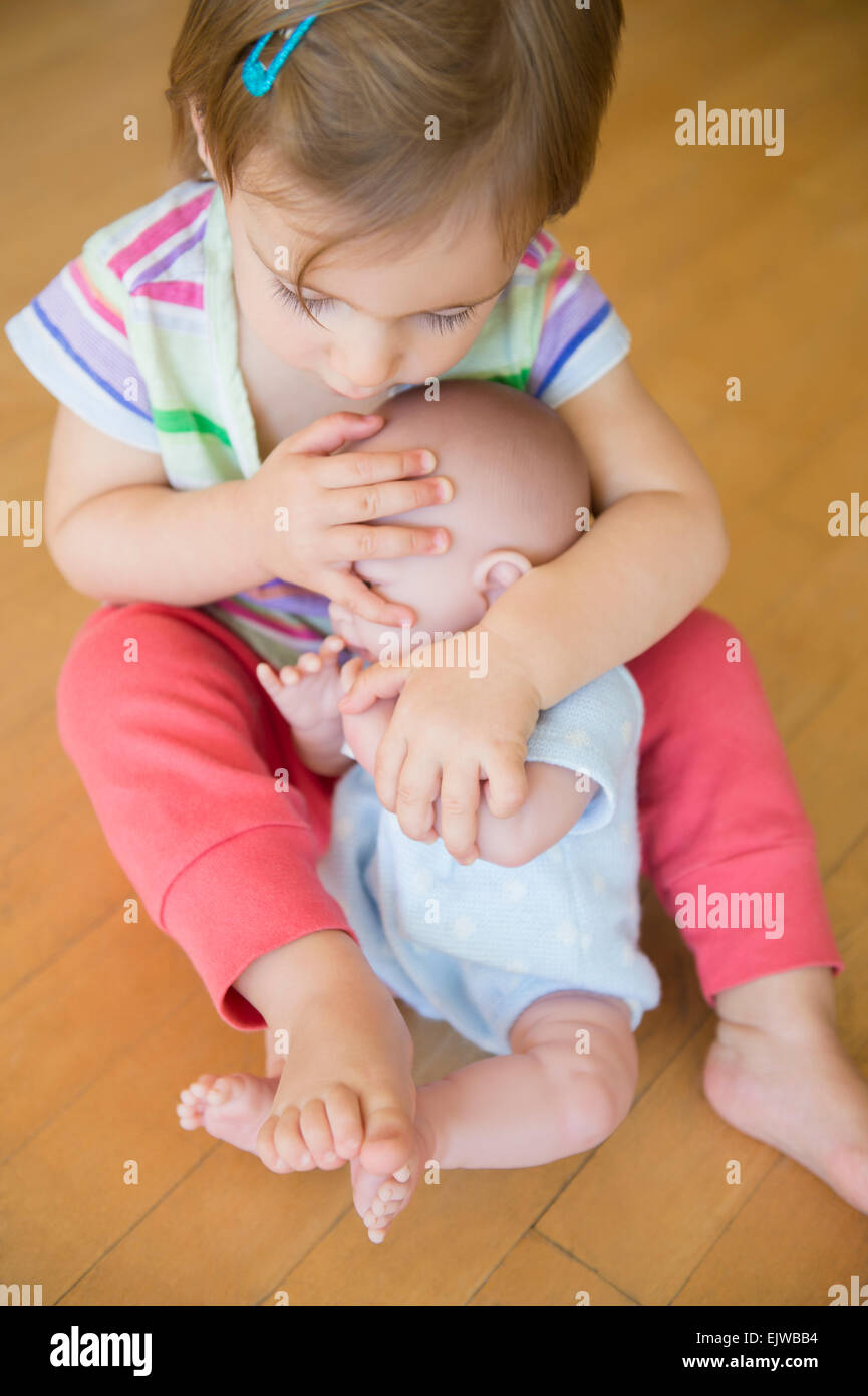 Mädchen (2-3) umarmt ihre Puppe Stockfoto