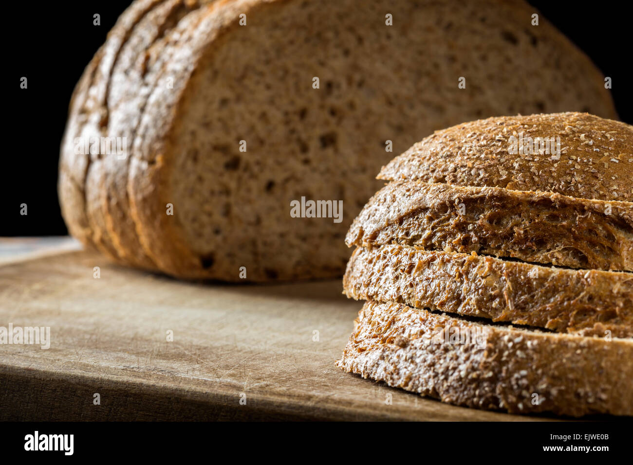 Scheiben Schwarzbrot auf einem Holztisch Stockfoto