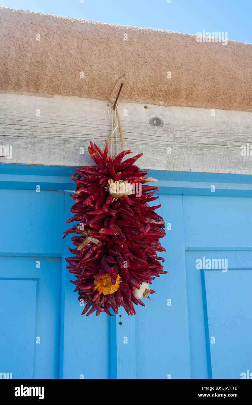 USA New Mexico NM Ranco de Taos Adobe Wand und Tür Detail mit Chile Girlanden über der Tür hängen Stockfoto