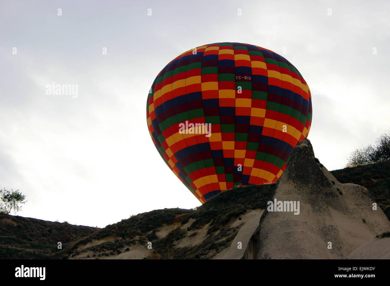 Heißluftballon steigen aus dem Tal hinter dem Hügel, Göreme, Cappadocia. Stockfoto