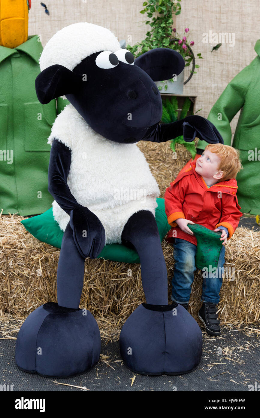 Shaun das Schaf freundet sich mit Teddy Darby, 3, aus der Lesung. Kew Gardens' Easter Festival "Shaun das Schaf" öffnet in Kew Gardens am 28. März und läuft bis 12. April 2015. Stockfoto