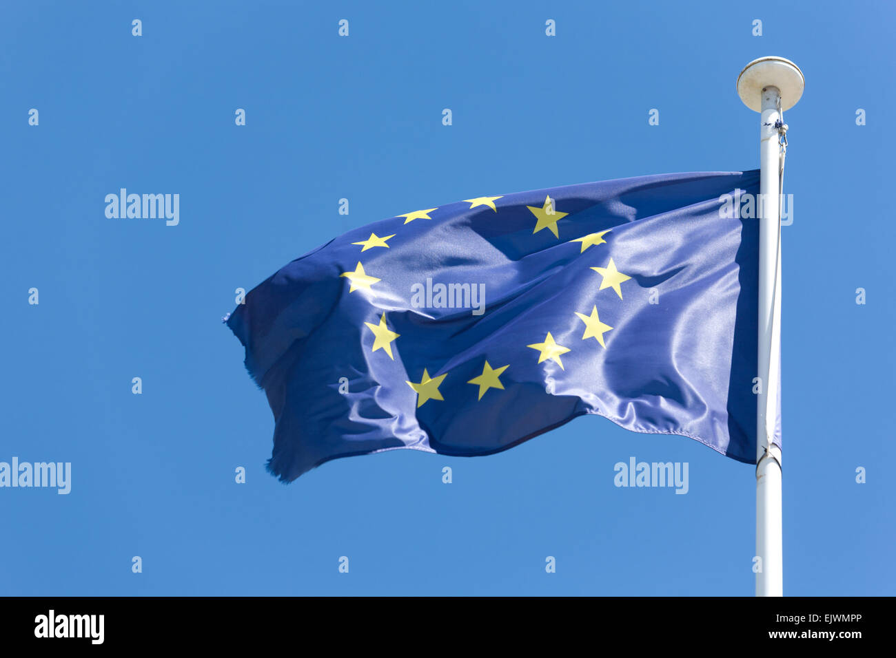 EU-Flagge flattern in einer lebhaften Brise vor blauem Himmel Stockfoto