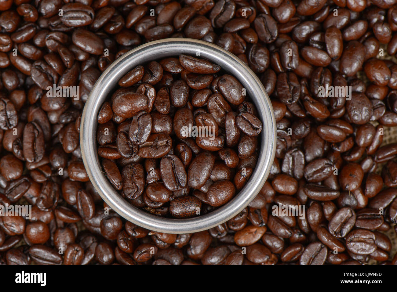 Nahaufnahme der Kaffeebohnen in einem Edelstahl Espresso Filterkorb. Stockfoto