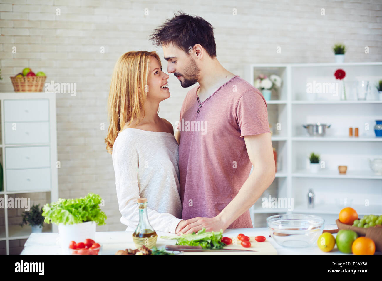Glückliches junges Paar von Vegetariern flirten in der Küche Stockfoto