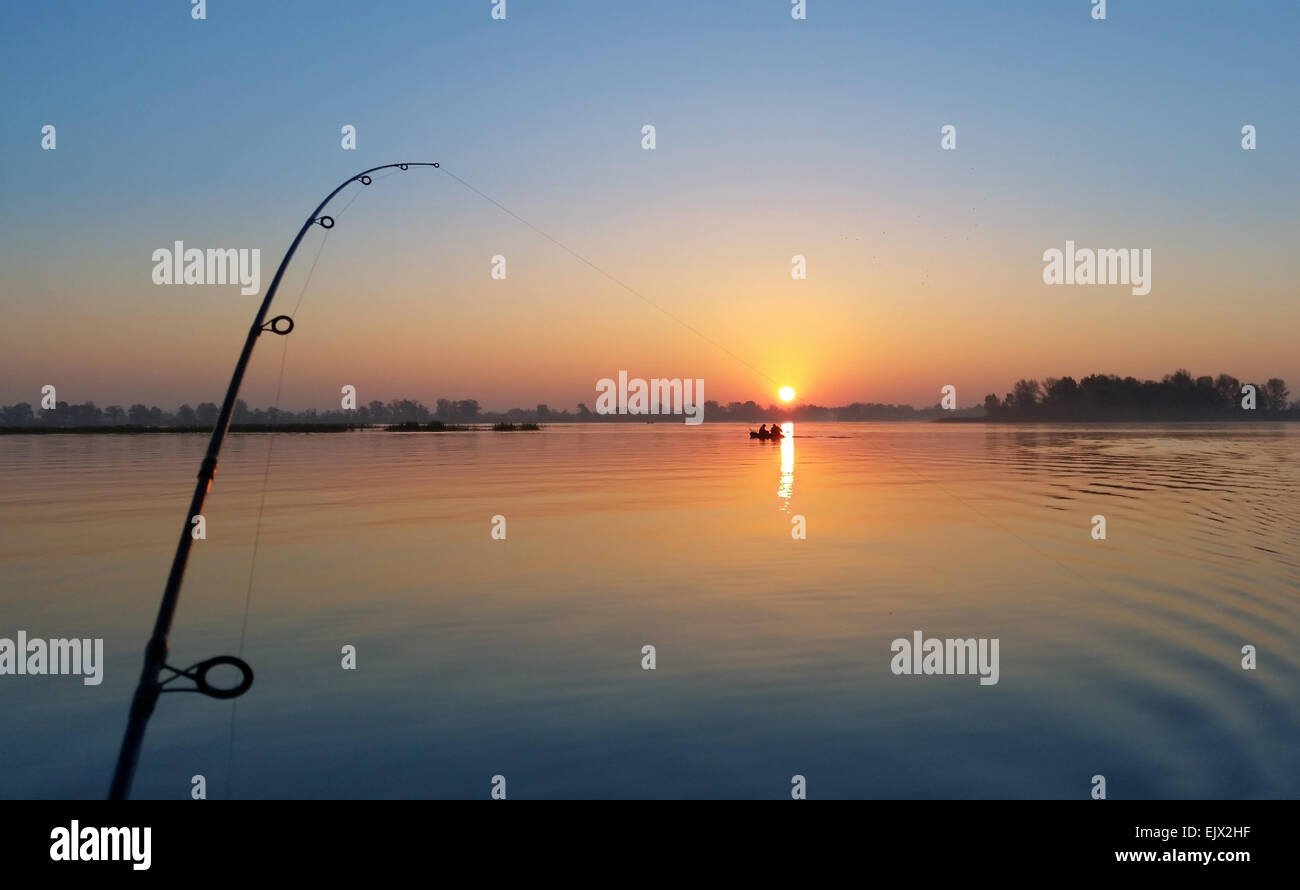 Nach unten rigging Angelrute an den Sonnenaufgang am Ufer Flusses. Stockfoto