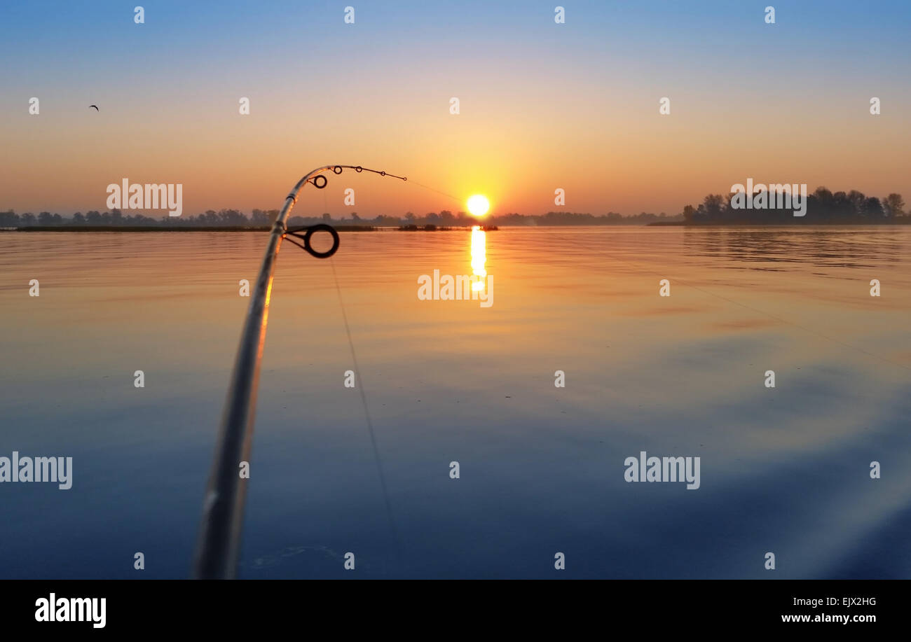 Nach unten rigging Angelrute an den Sonnenaufgang am Ufer Flusses. Stockfoto