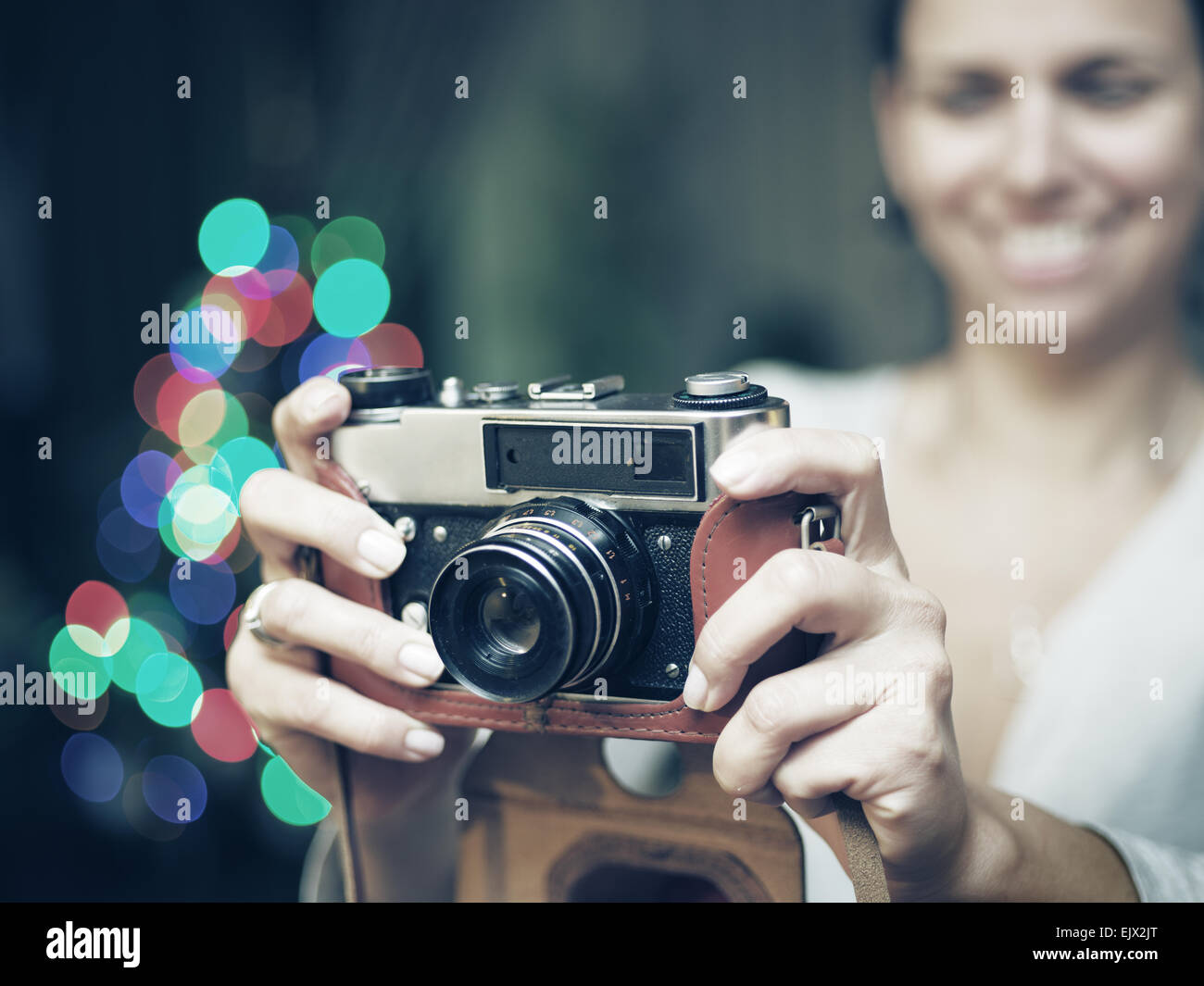 Lächelnde Frau fotografiert Retro-Kamera. Vintage Bildverarbeitung. Stockfoto