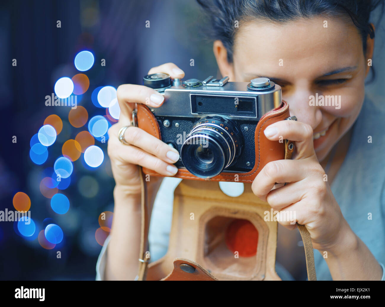 Lächelnde Frau fotografiert Retro-Kamera. Vintage Bildverarbeitung. Stockfoto