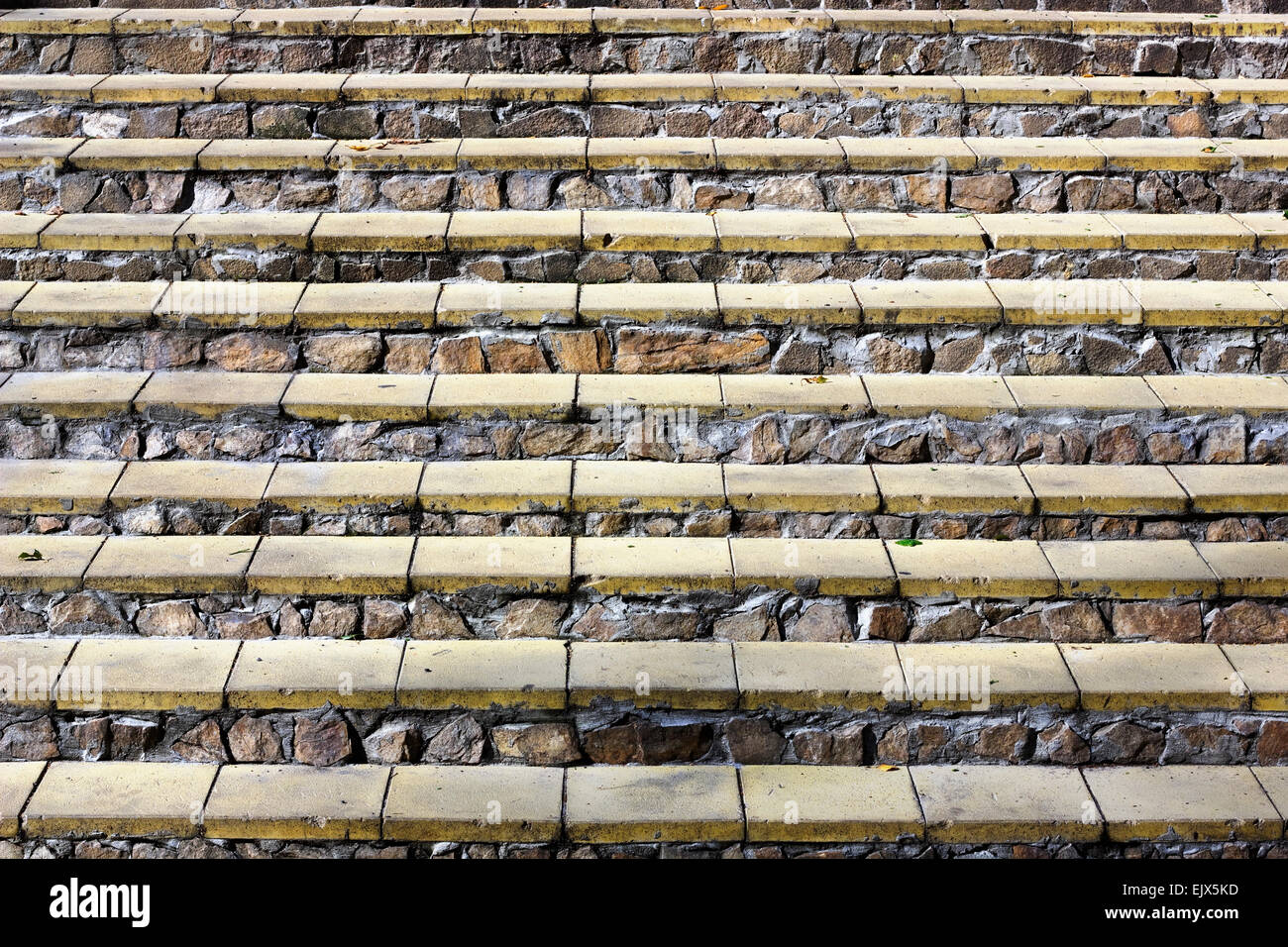 Horizontale Schritte von einer Leiter aus gelben Ziegeln und Granit Rohsteine Hintergrund Stockfoto