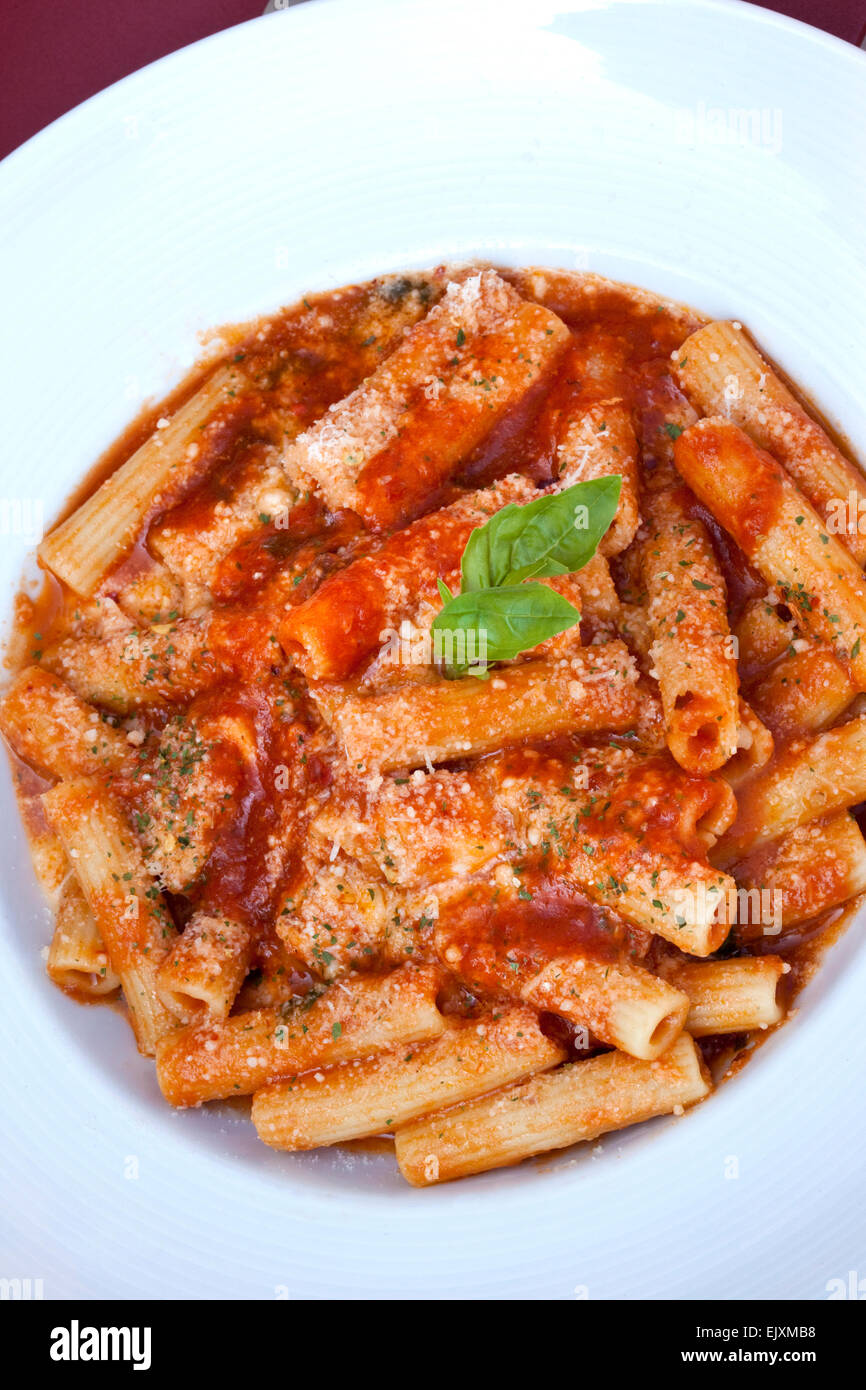 Nudeln, Tomatensauce, Basilikum und Parmesan auf einem Teller Stockfoto