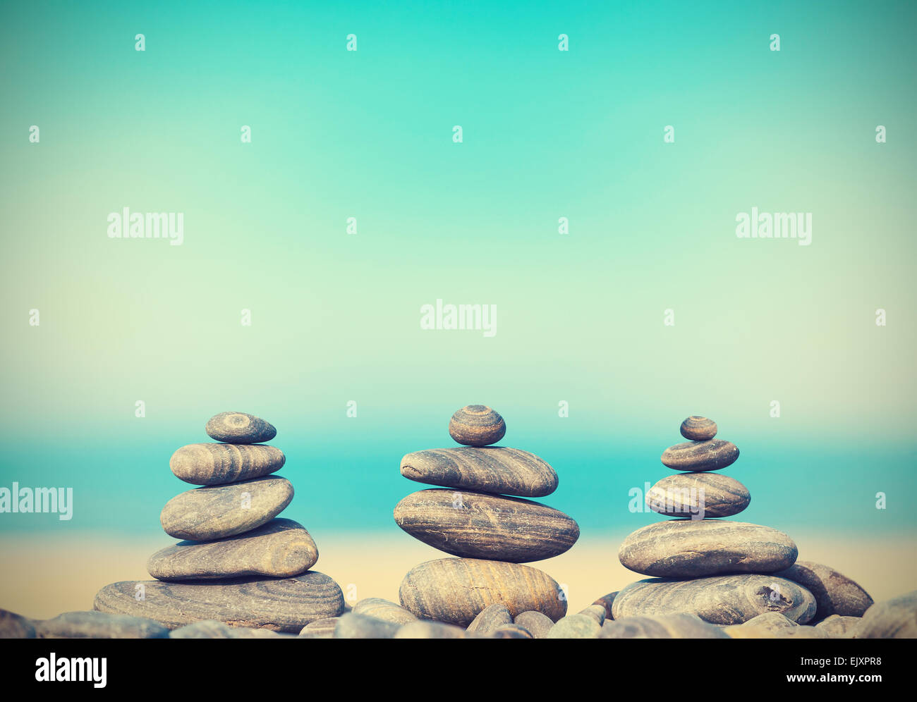 Vintage-Retro-Stil Bild Steinpyramiden am Strand, Zen Spa Konzept Hintergrund. Stockfoto