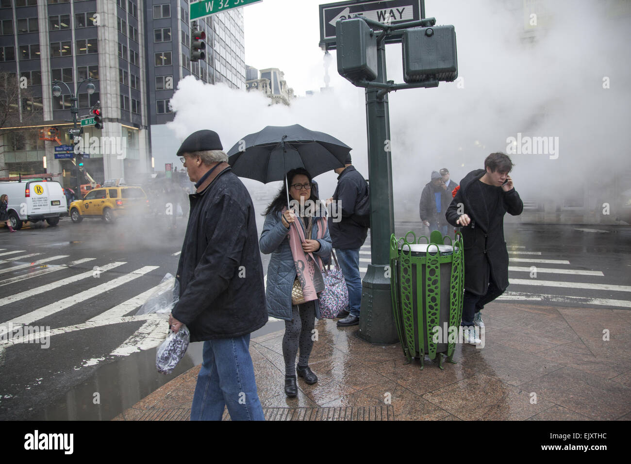 Vom Himmel regnen und Dampf freigesetzt unter der Straße in Midtown Manhattan, Broadway & 32nd Street, NYC. Stockfoto