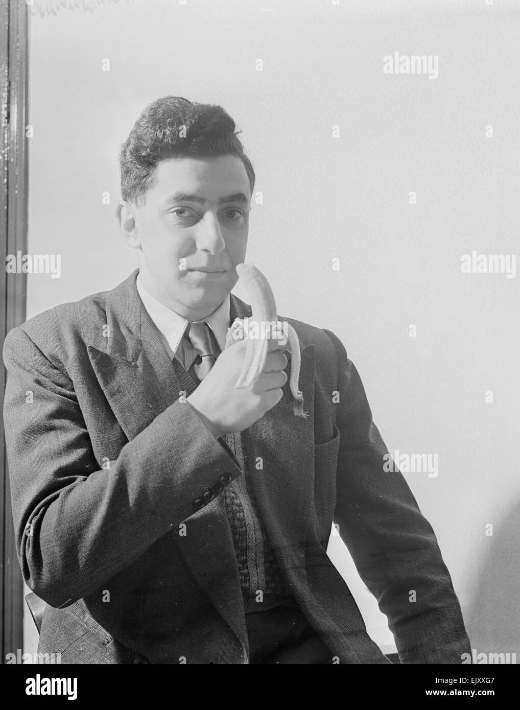Mann eine Banane essen. 27. April 1953 zur Veranschaulichung der Lockerung der Rationierung Stockfoto