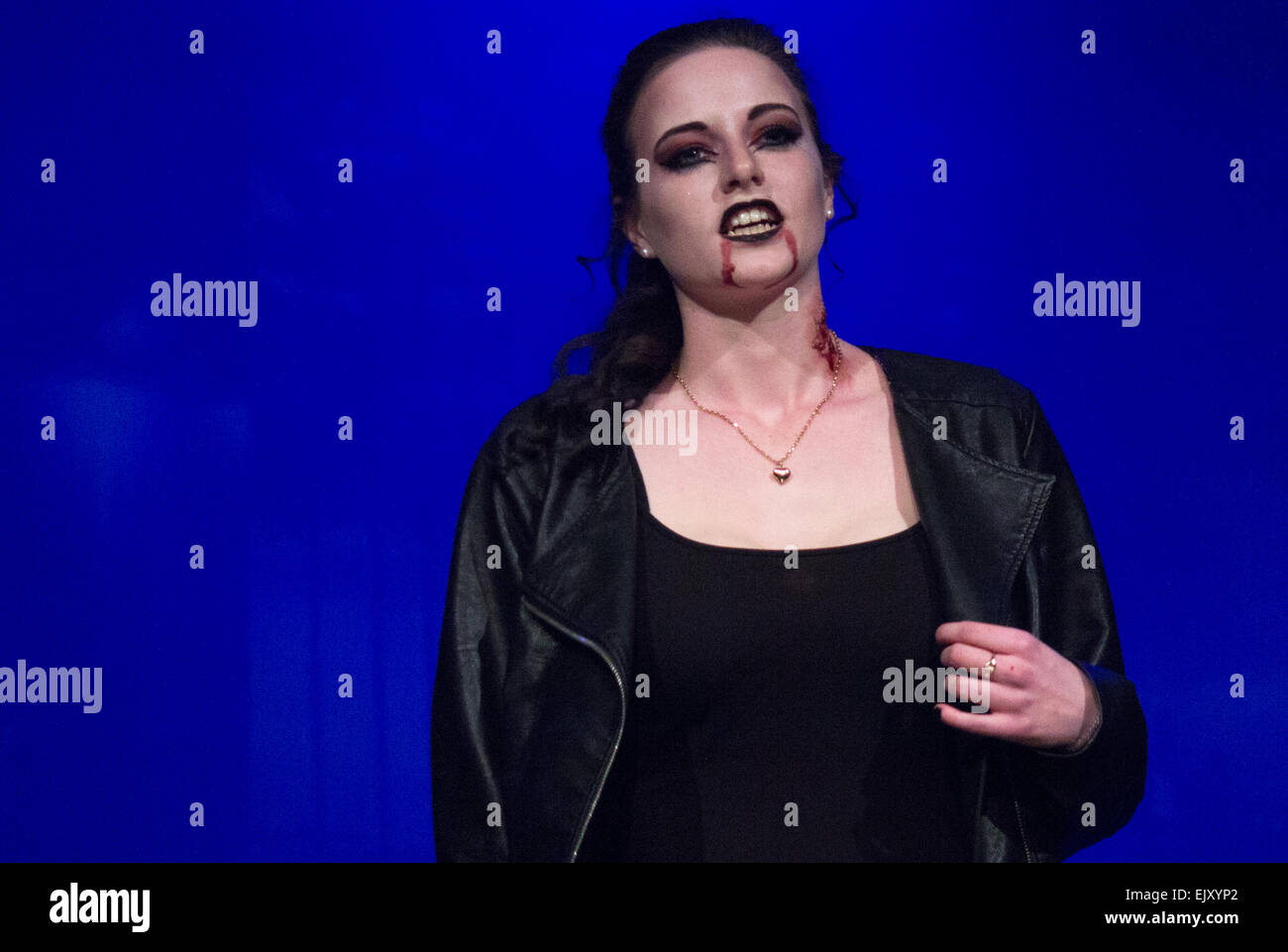 Blasses weibliches Modell in blutigen Bühne Make-up einschließlich schneidet, Blut läuft aus Mund, schwarzer Lippenstift und schweren schwarzen Eyeliner. Stockfoto