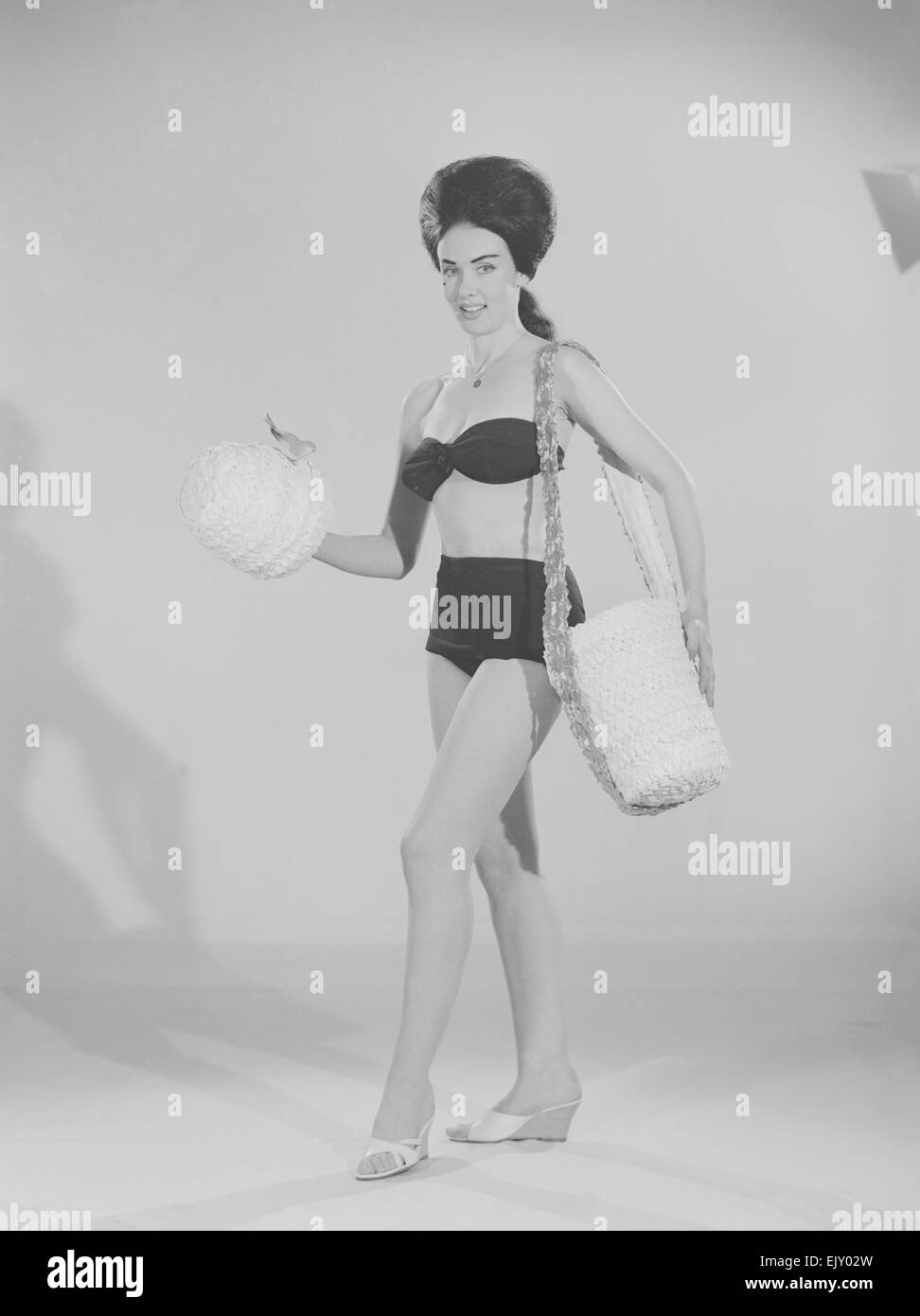 Tagwache Mode Feature Reveille Modell Barbara Turner gesehen hier Modellierung einen Strandhut und Tasche. April 1963 Stockfoto