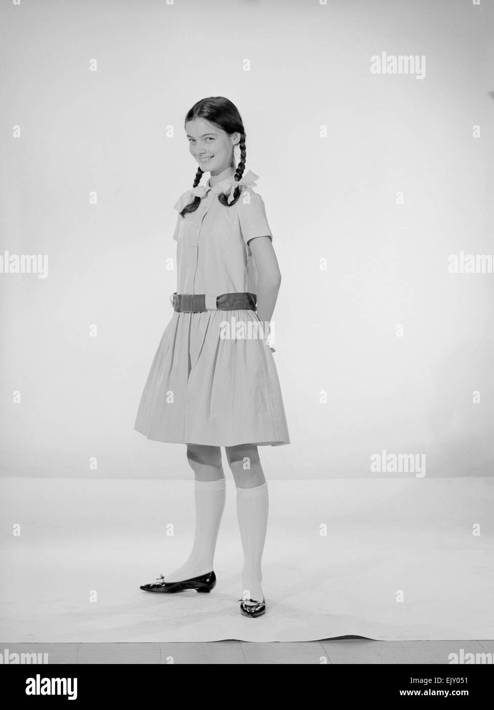 Modell Jennifer Goddard. Braunhaarige Mädchen im karierten Kleid mit Pig tails Stockfoto