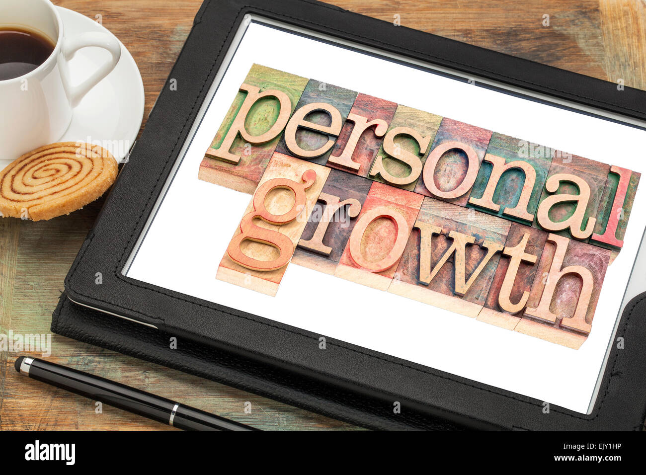 persönliches Wachstum Typografie - Text im Buchdruck Holzart auf einem digitalen Tablet mit einer Tasse Kaffee Stockfoto