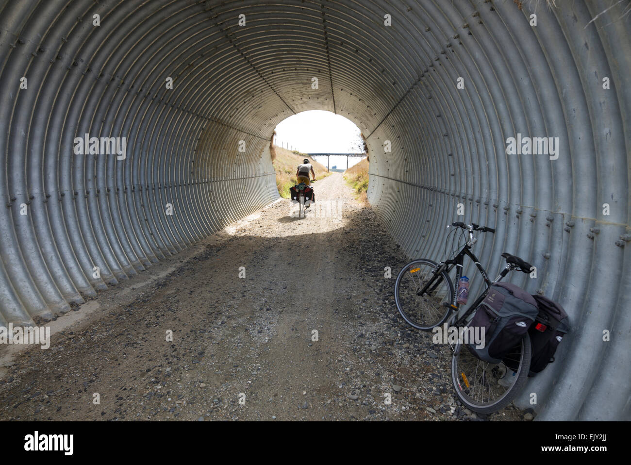 Ein Radfahrer führt durch einen Tunnel auf der Central Otago Rail Trail, Südinsel, Neuseeland. Stockfoto