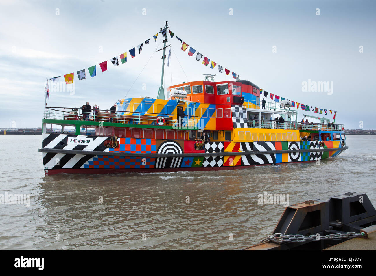 Die erste Segelfahrt der neu angestrichenen Dazzle Mersey Ferry im April 2015, die ein Schiff über den Fluss Mersey betreibt. Das von Sir Peter Blake im Rahmen der gedenkfeiern zum Ersten Weltkrieg geschaffene Gemälde Dazzle Ferry wurde entworfen. River Explorer Cruise an Bord von Snowdrop, dem bunt bemalten Dazzle Ferry Boat. Die Fähre wurde als „sagenhaftes Schiff“ ausgewählt und erhielt eine einzigartige neue Lackierung, die von der Blendle-Tarnung des Ersten Weltkriegs inspiriert wurde Stockfoto
