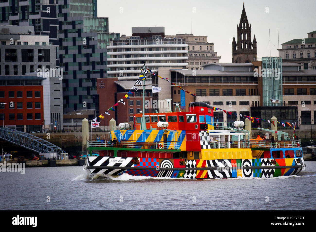 Die erste Segelfahrt der neu angestrichenen Dazzle Mersey Ferry im April 2015, die ein Schiff über den Fluss Mersey betreibt. Das von Sir Peter Blake im Rahmen der gedenkfeiern zum Ersten Weltkrieg geschaffene Gemälde Dazzle Ferry wurde entworfen. River Explorer Cruise an Bord von Snowdrop, dem bunt bemalten Dazzle Ferry Boat. Die Fähre wurde als „sagenhaftes Schiff“ ausgewählt und erhielt eine einzigartige neue Lackierung, die von der Blendle-Tarnung des Ersten Weltkriegs inspiriert wurde Stockfoto