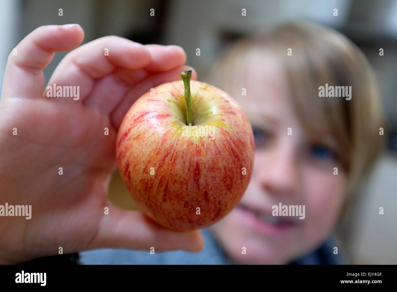 ein Kind hält einen Apfel Stockfoto