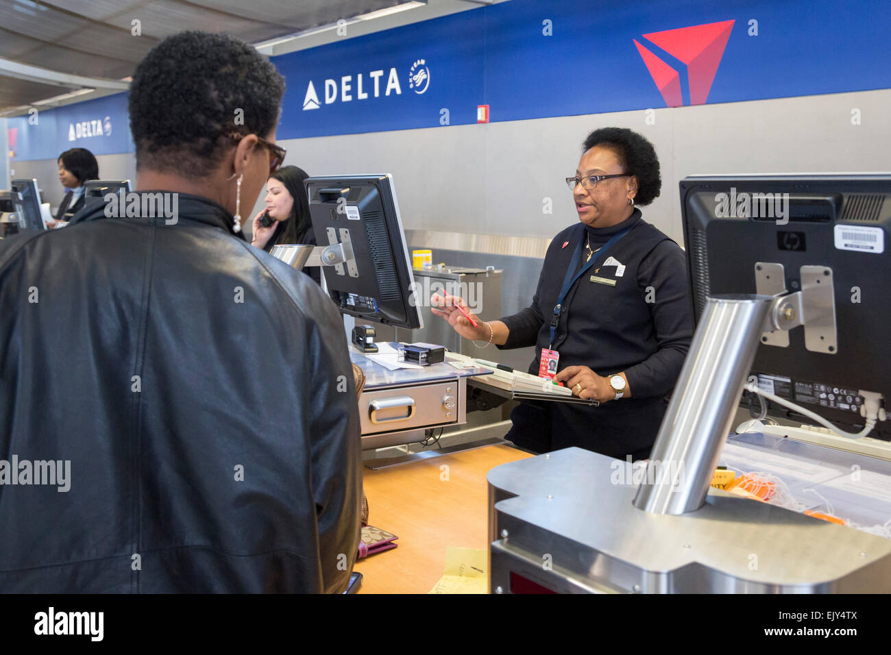 Romulus, Michigan - A Delta Air Lines Ticket-Agent überprüft in einem Passagier nach Detroit Metro Airport Stockfoto