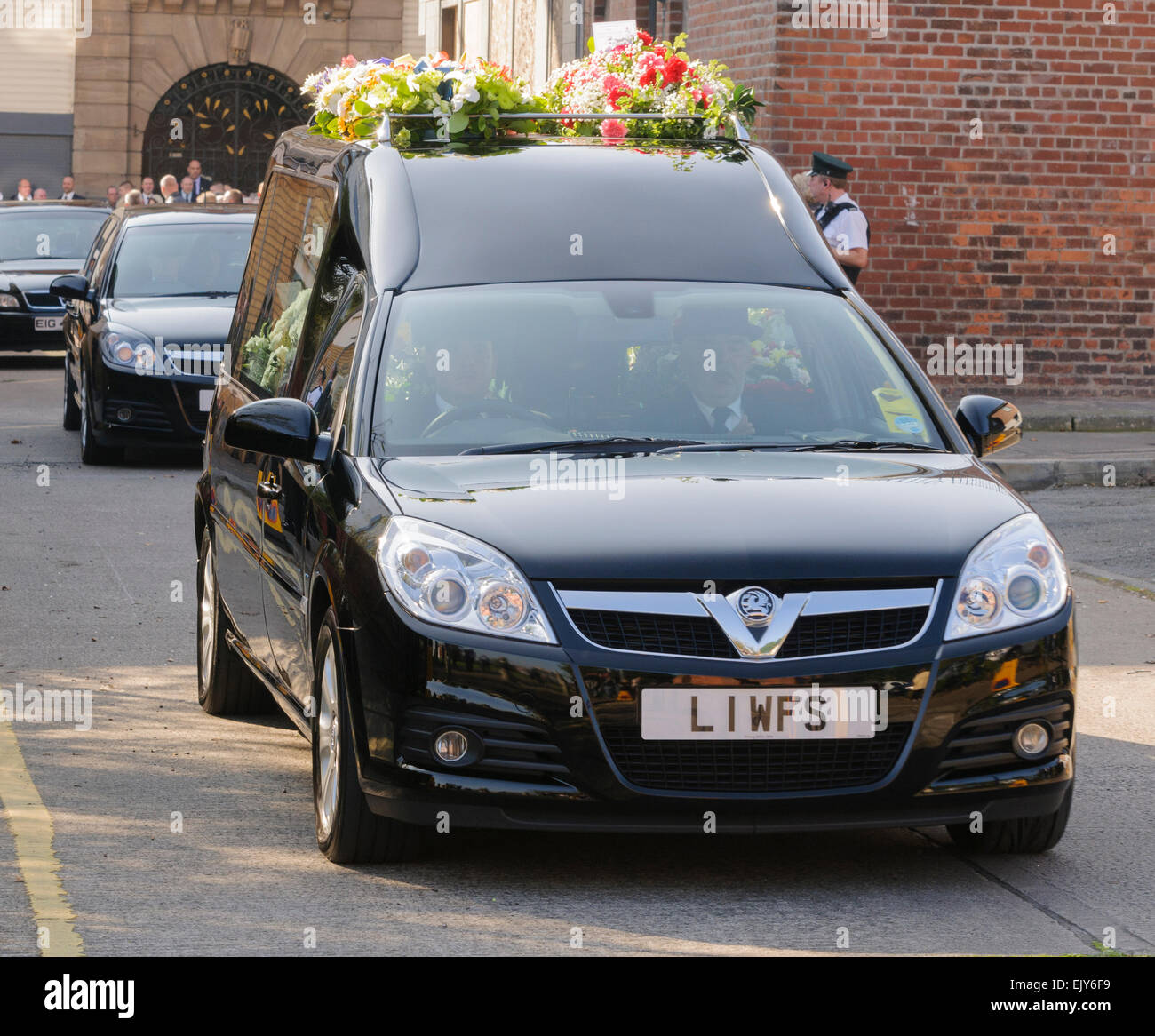 Leichenwagen Fahrt entlang einer Straße bei einer Beerdigung. Stockfoto