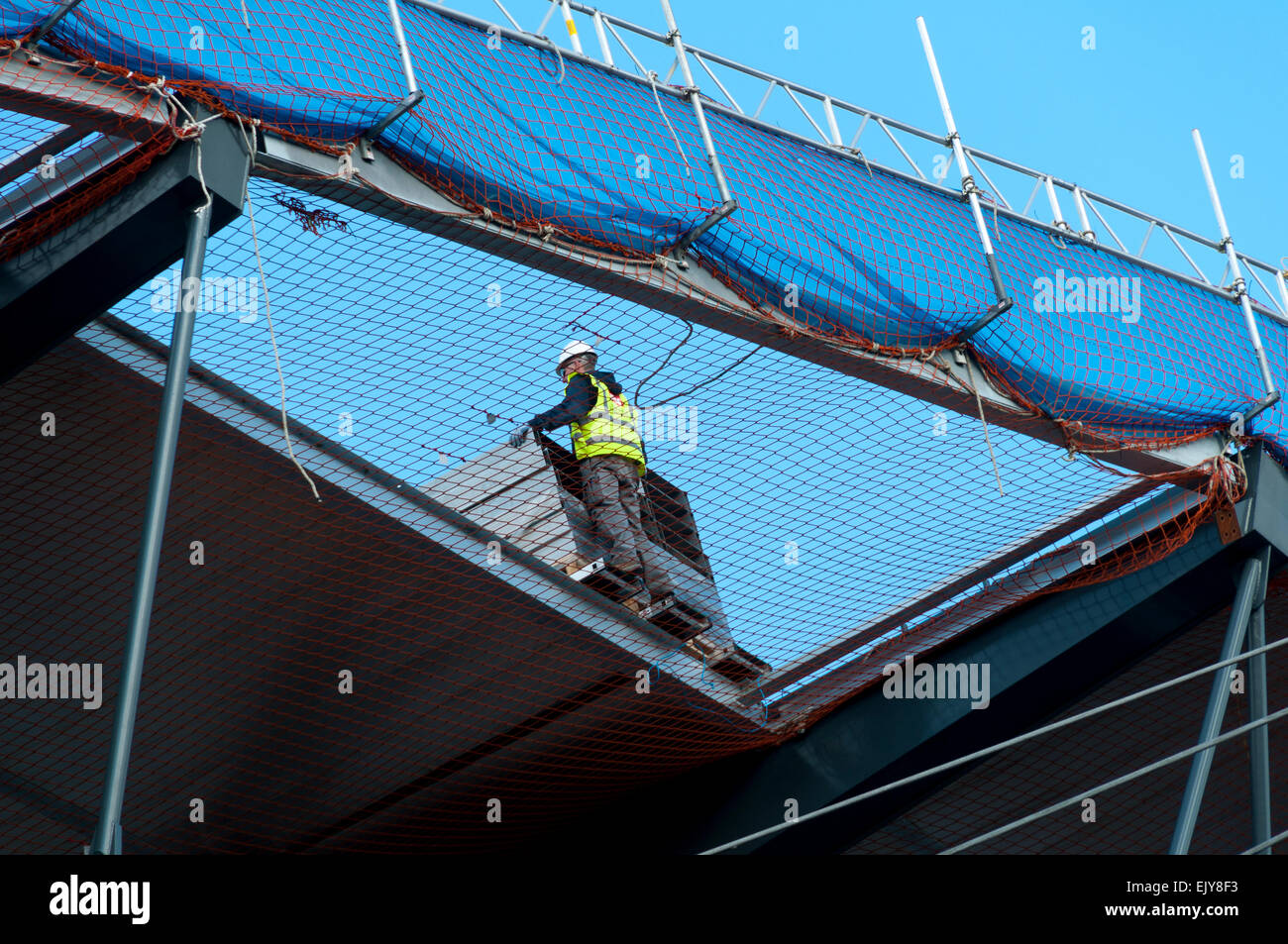 Arbeiter über Sicherheit Verrechnung auf dem Dach der Etihad Stadium, South Expansion Projekt Stand, Manchester, England, Großbritannien Stockfoto