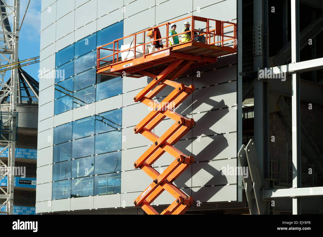 Arbeiter auf eine Teleskop Schere zugreifen Plattform, Etihad Stadium, Südtribüne Expansion Projekt, Manchester, England, UK Stockfoto