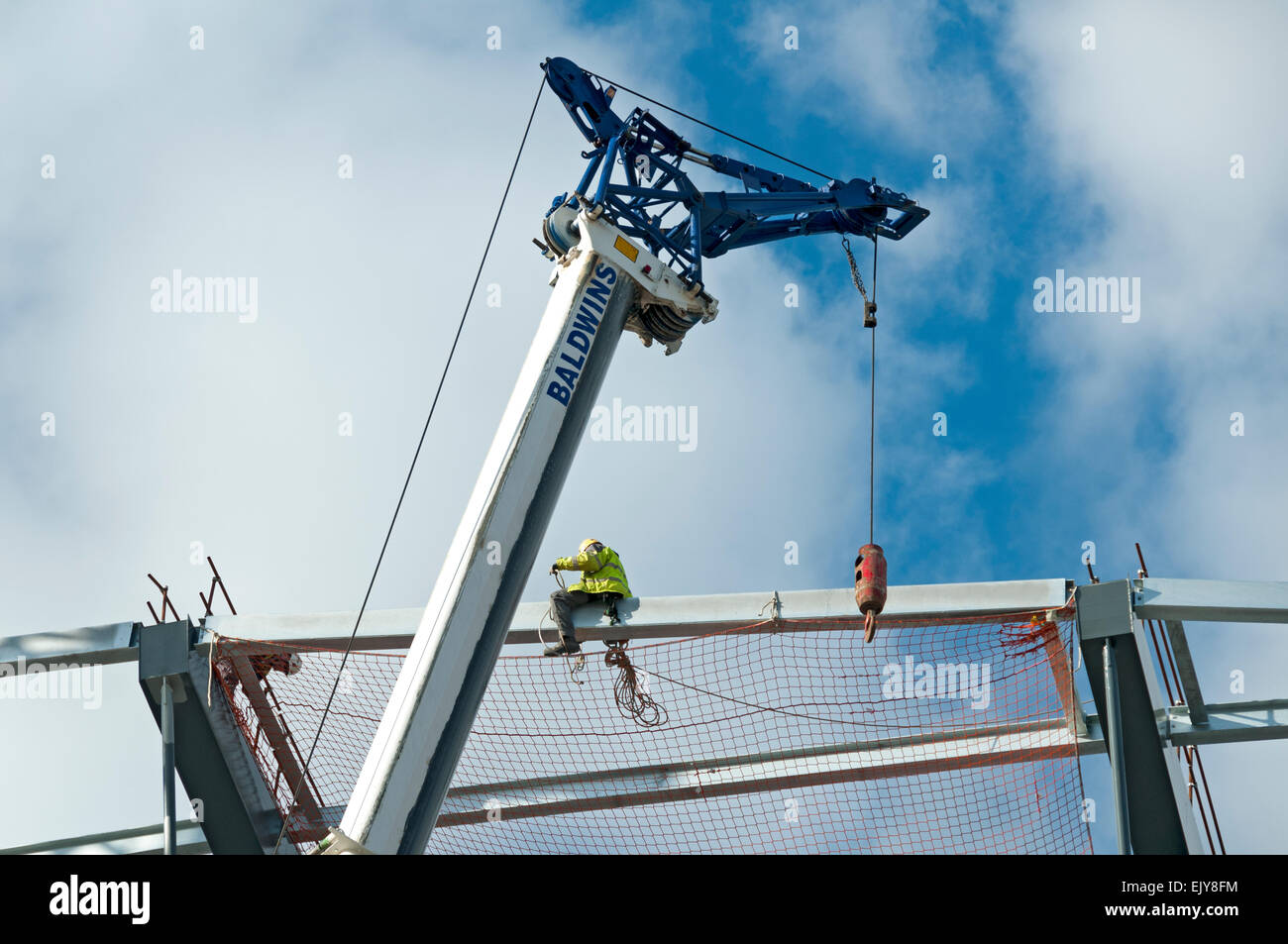 Workman Befestigung Sicherheit Netz auf dem Dach des Etihad Stadium, Südtribüne Erweiterungsprojekt, Manchester, England, UK Stockfoto