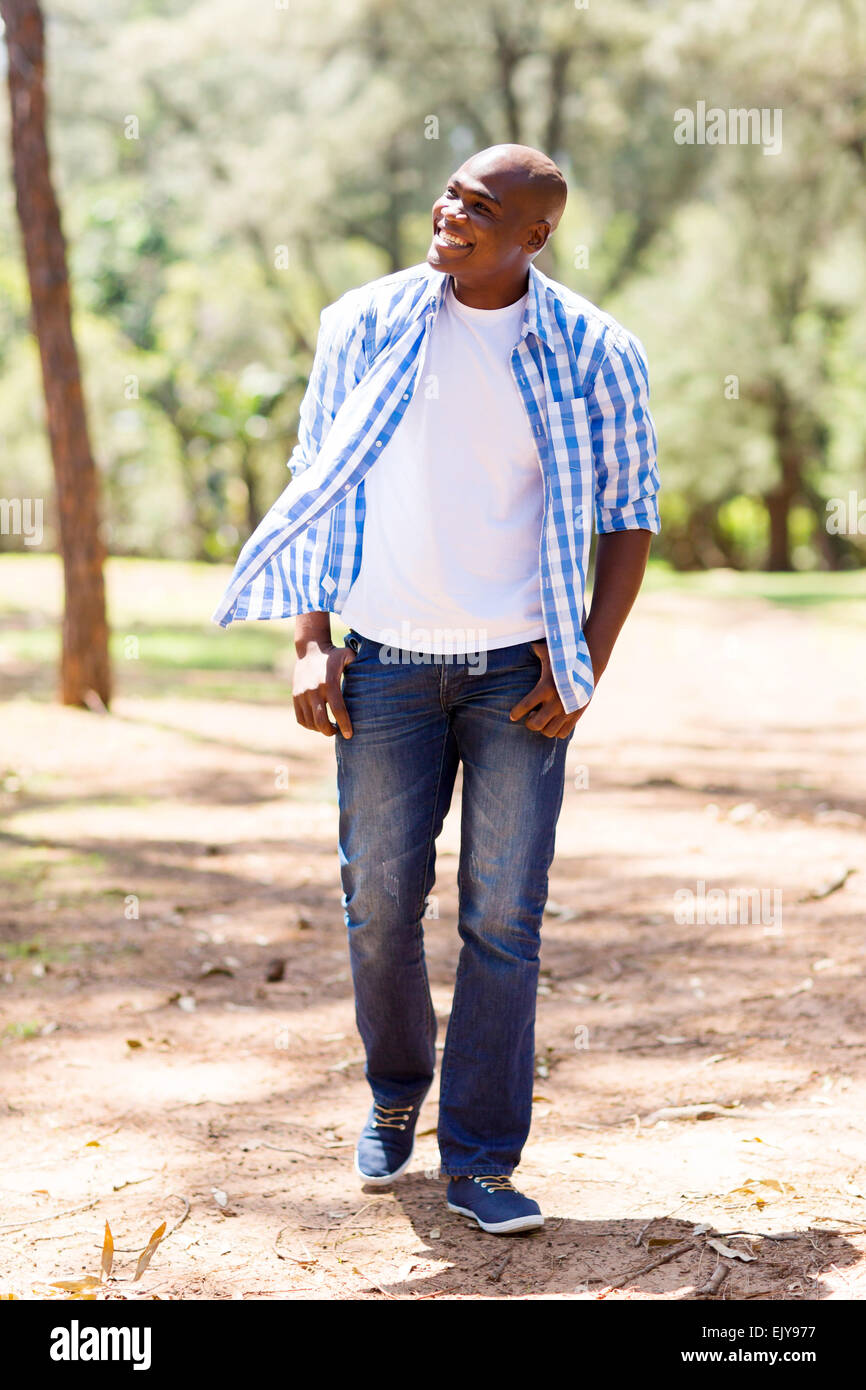 Lässige junge afroamerikanische Mann im Park spazieren und wegsehen Stockfoto