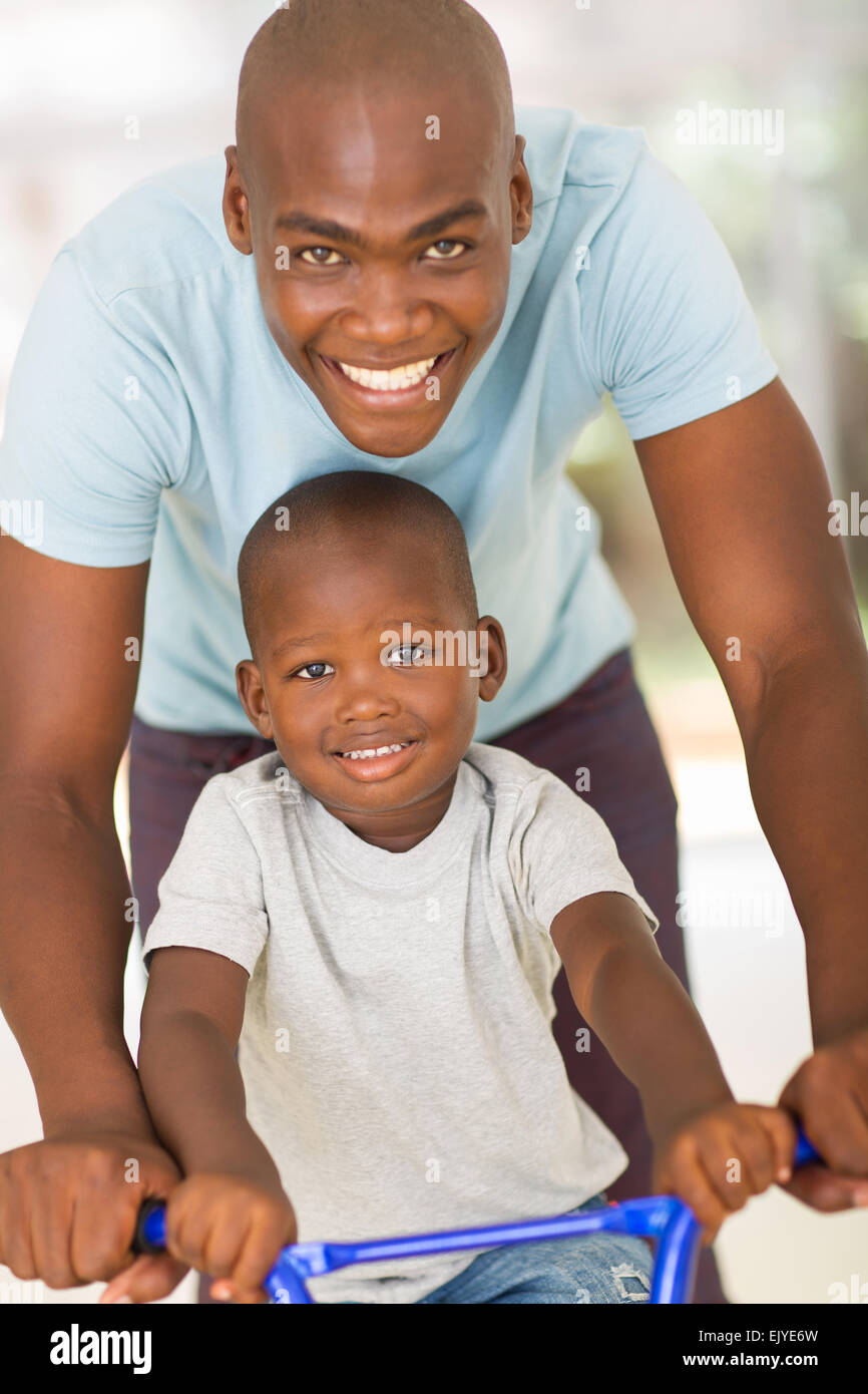 Pflege jungen afrikanischen Vater Sohn auf einem Fahrrad schieben Stockfoto