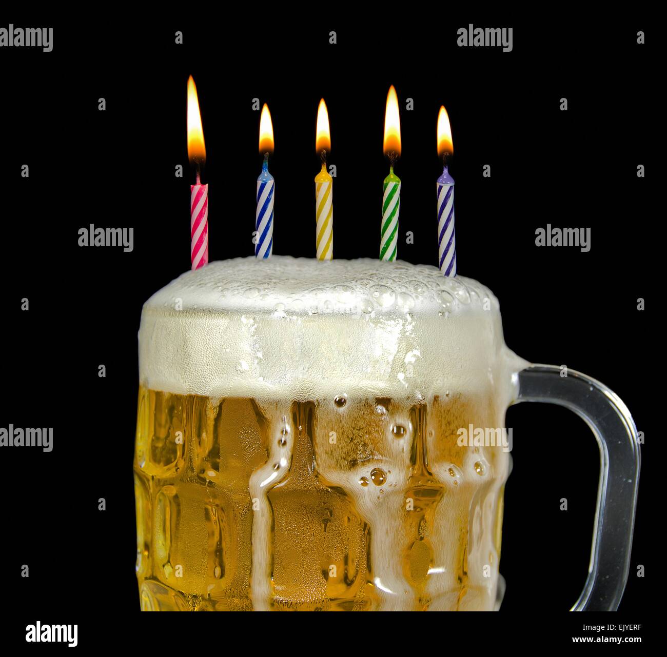 Geburtstagskerzen in einem Krug Bier mit Schaum. Stockfoto