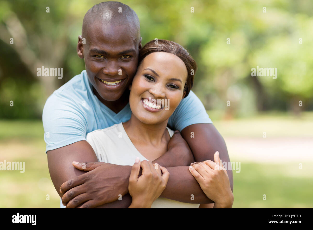 gut aussehende afrikanische Mann umarmt Freundin im freien Stockfoto