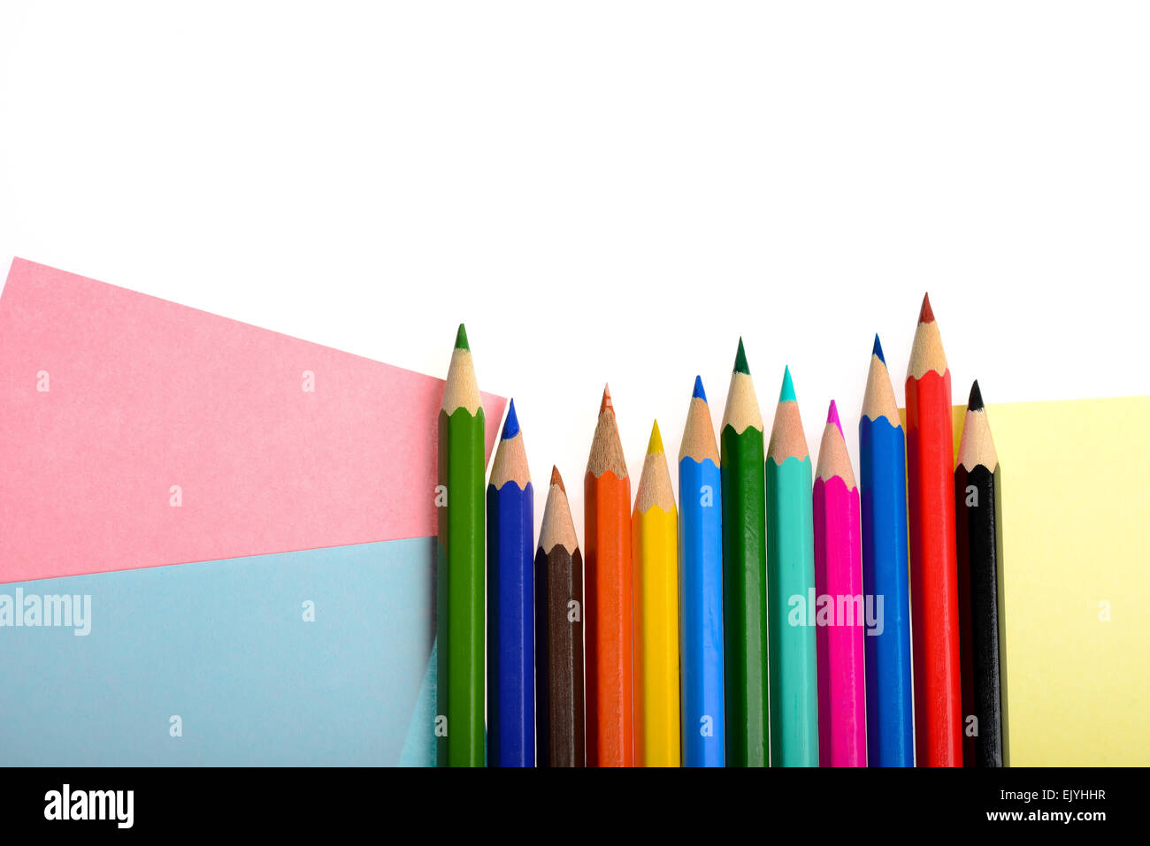 Buntes Papier und Stifte, die isoliert auf weißem Hintergrund Stockfoto