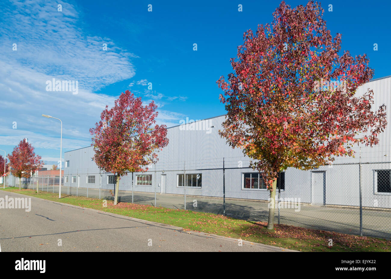 moderne Fassade eines Industriebaus, umgeben von einem Zaun mit Tor Stockfoto