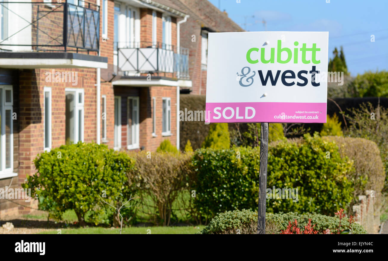 Cubitt & West Immobilienmakler verkauft Zeichen vor einem Haus. Stockfoto