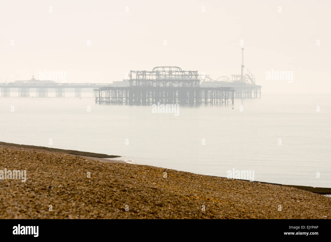 Piers im Nebel, Brighton Pier West und Palace Pier an einem nebligen Morgen Stockfoto
