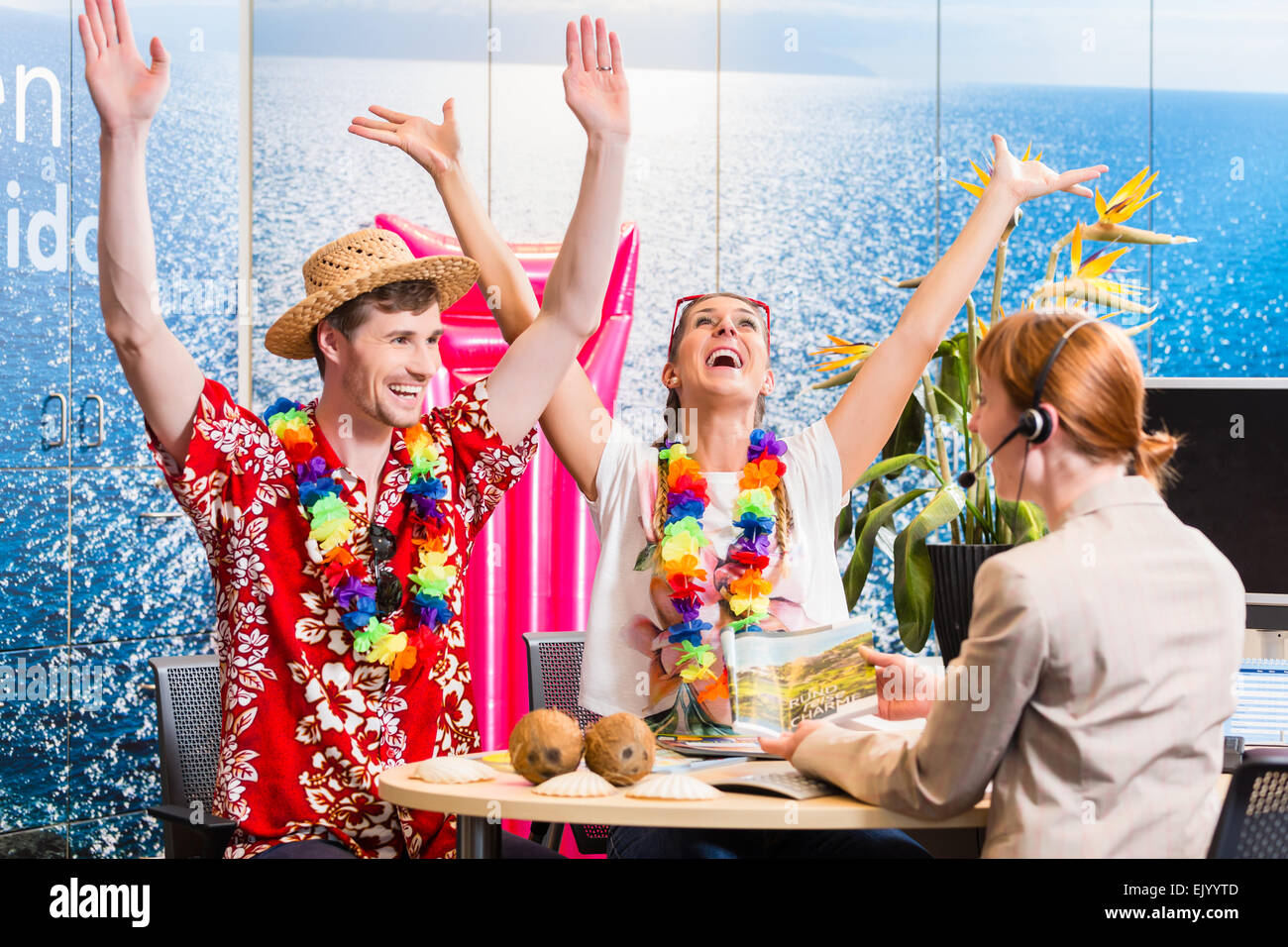 Mann und Frau Buchung Urlaub im Reisebüro Jubel für ein gutes Geschäft Stockfoto