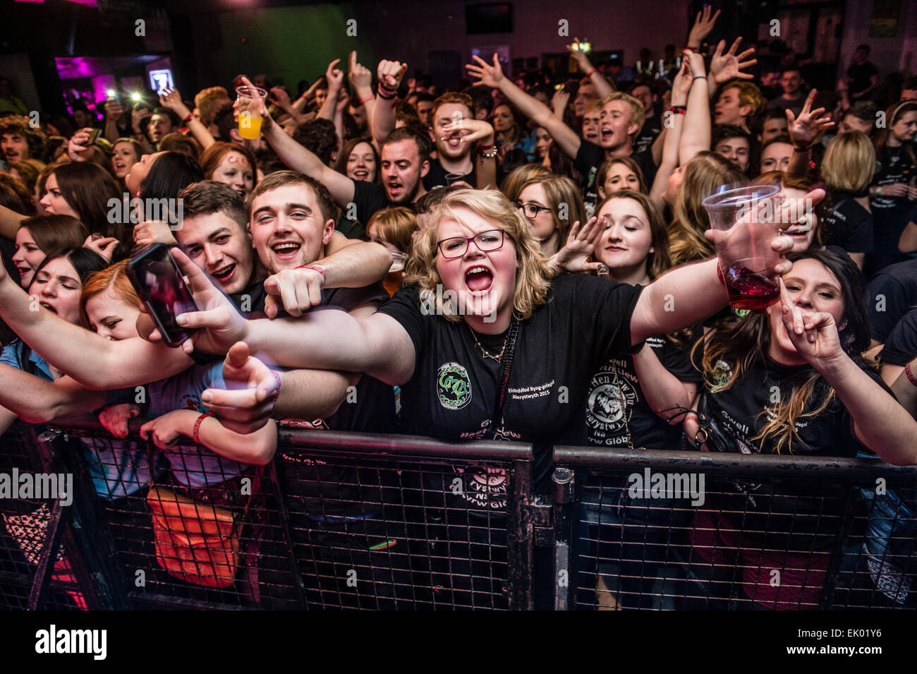 Partylöwen: Scharen von jungen College-Studenten amüsieren sich schreien und singen in einem walisischen Sprache Rockmusik Konzert Tanz Partynacht in Aberystwyth University Studenten Union. Stockfoto