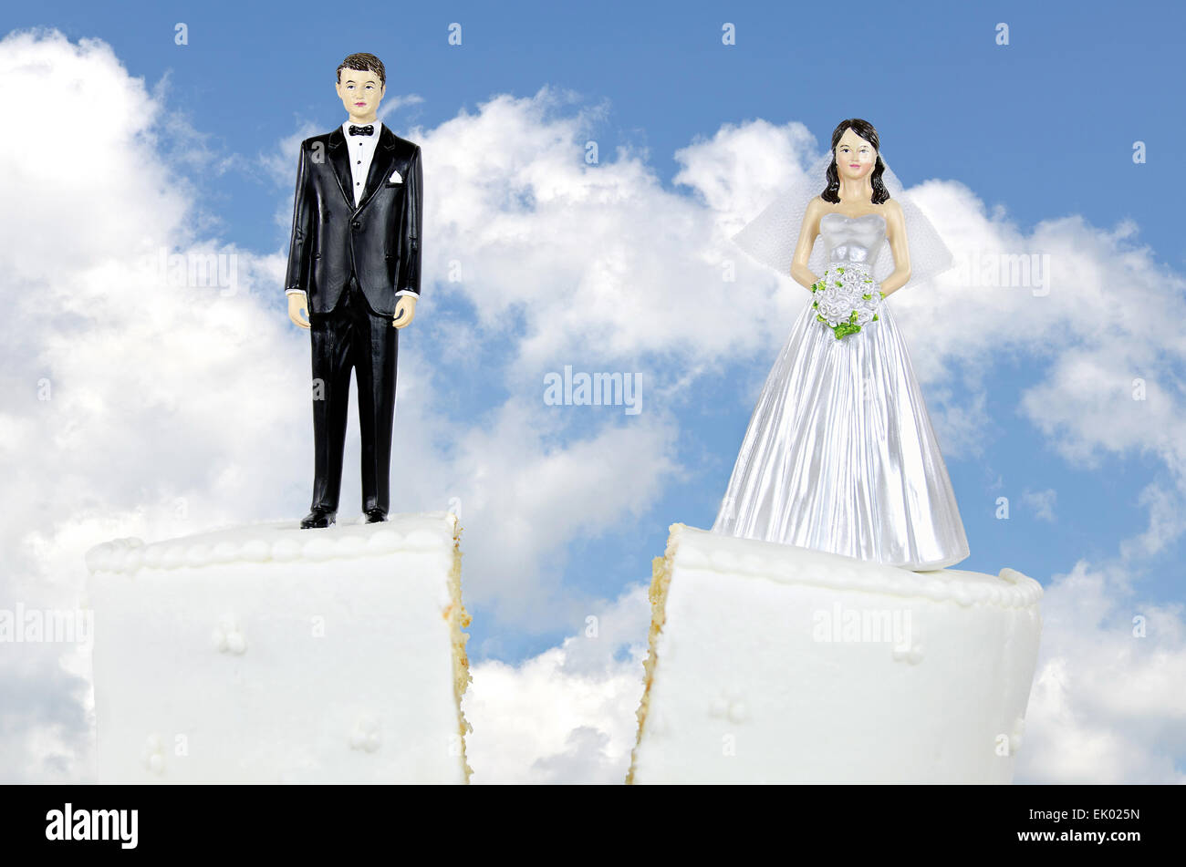 Braut und Bräutigam auf Split Hochzeitstorte mit Himmelshintergrund. Stockfoto