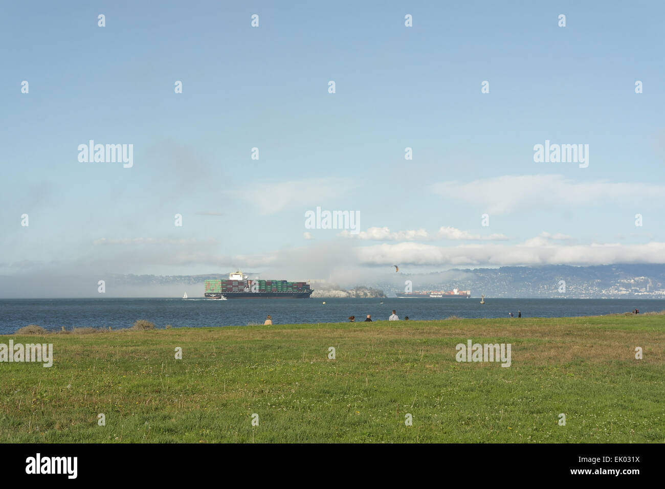 Blauer Himmelsblick, Crissy Field nach Alcatraz, über Küste Rasen Ausdehnung in Richtung Containerschiff bewegen San Francisco Bay, USA Stockfoto