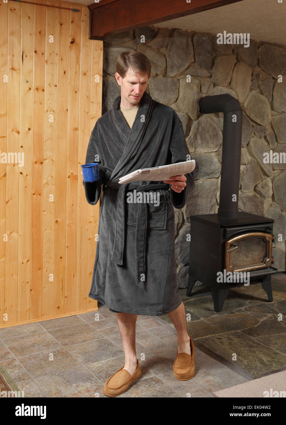 gut aussehender Mann trägt Gewand und gehen beim Zeitung lesen Stockfoto