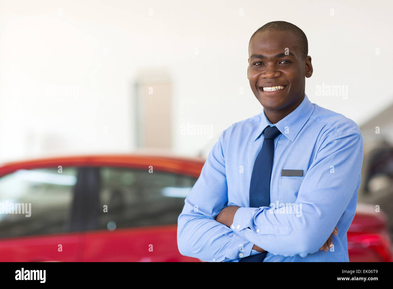 Porträt des afroamerikanischen Auto Verkaufsberater mit Armen gefaltet im showroom Stockfoto