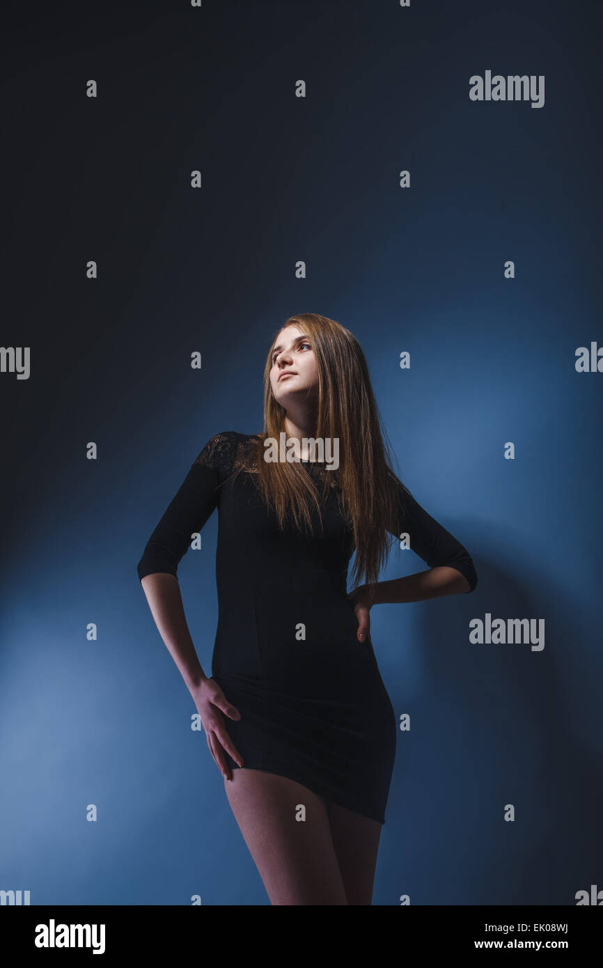 Europäisch anmutende Mädchen mit Brille im schwarzen Kleid, legte ihre Hand o Stockfoto