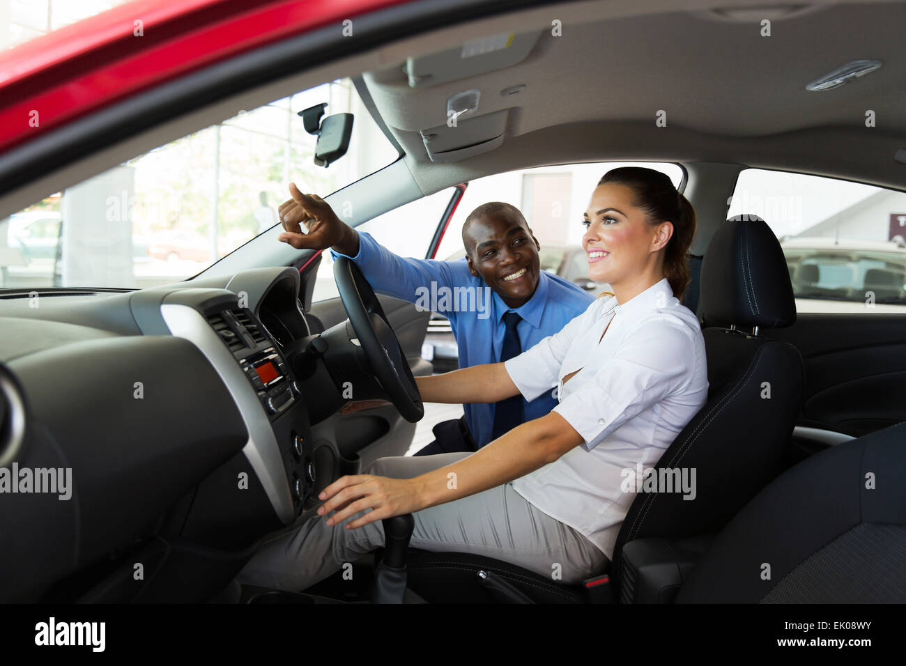 glückliche Verkäufer erklären Auto verfügt über junge Kundin Stockfoto