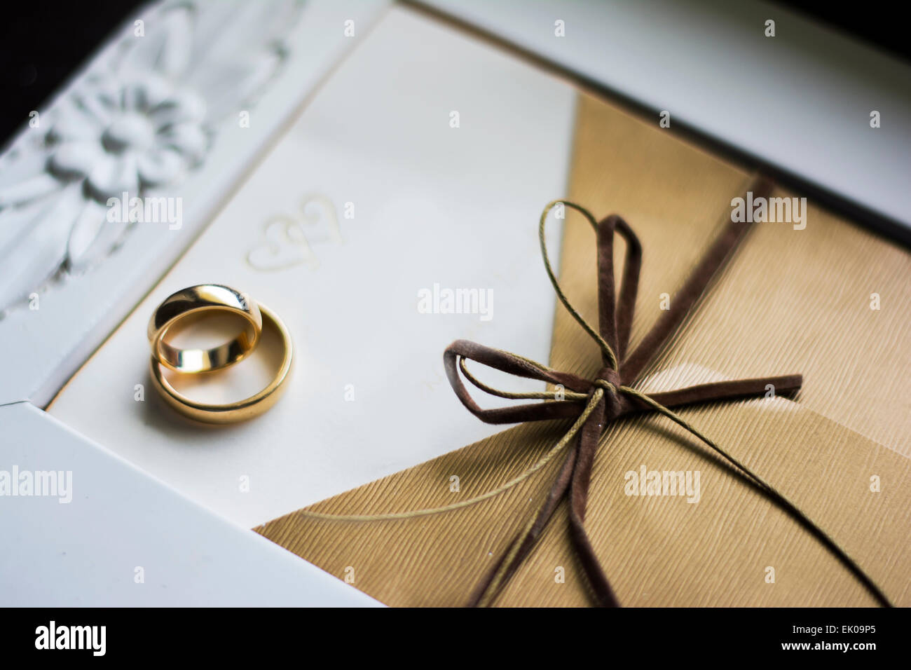 Trauringe auf der Hochzeitseinladung mit Fokus auf dem Bogen Stockfoto